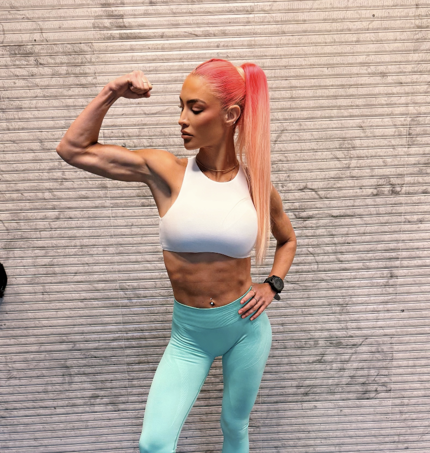 Natalie Eva Marie flexing her bicep, showing the strength results of the NEMFIT method
